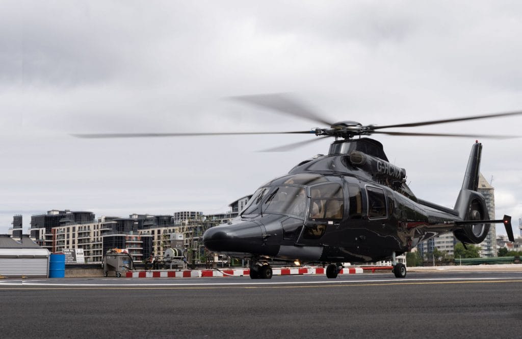 A helicopter landing on the pad by the Thames
