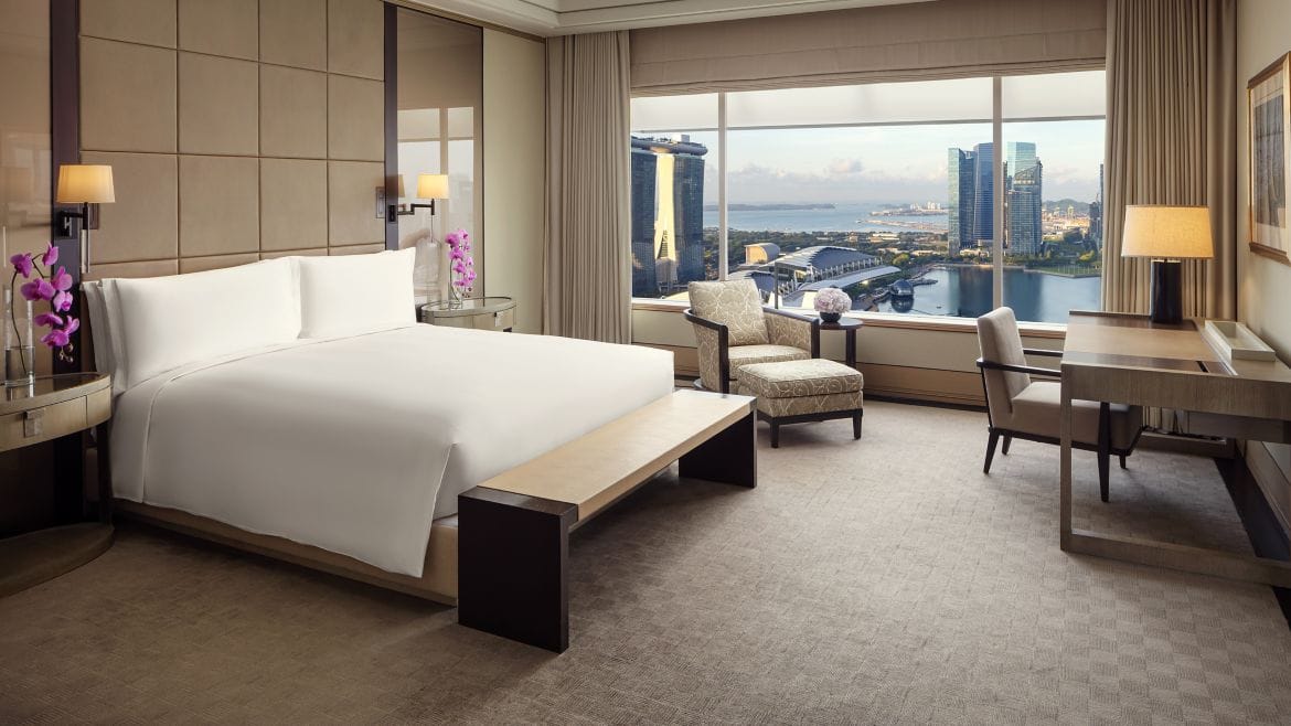 Schlafzimmer mit Kingsize-Bett über der Marina Bay