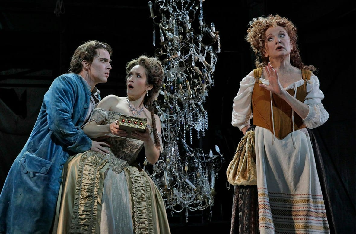 Candide, Cunegonde and the Old Lady beneath a chandelier