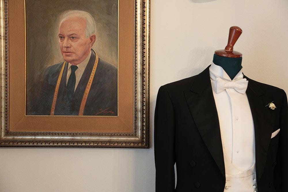 A tailcoat beside the founder's portrait
