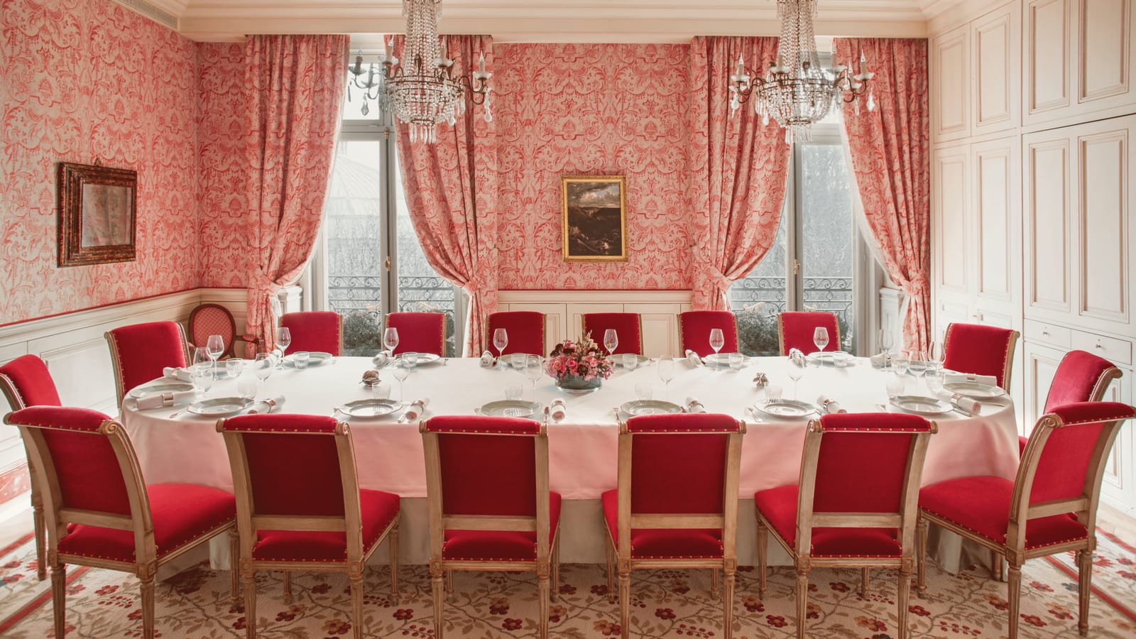 A private room set for dinner, windows to the trees