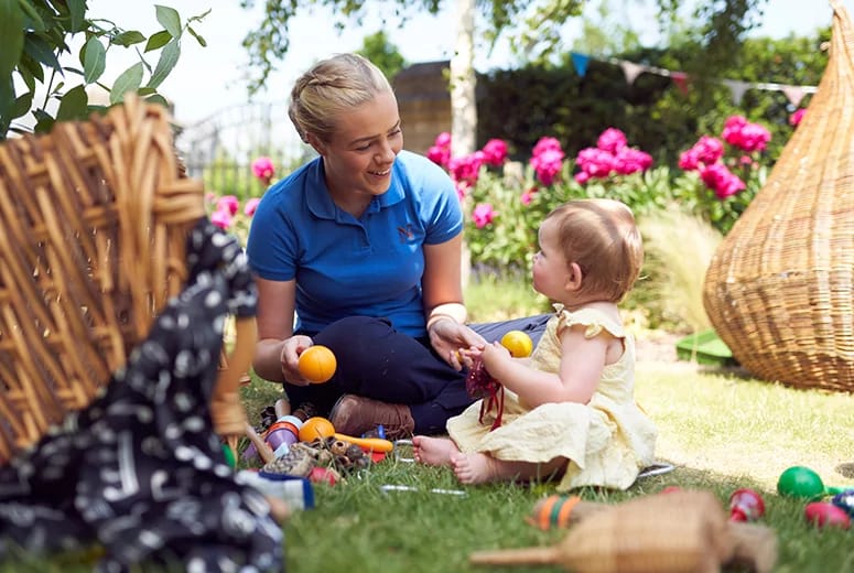 A nanny and a baby on the lawn