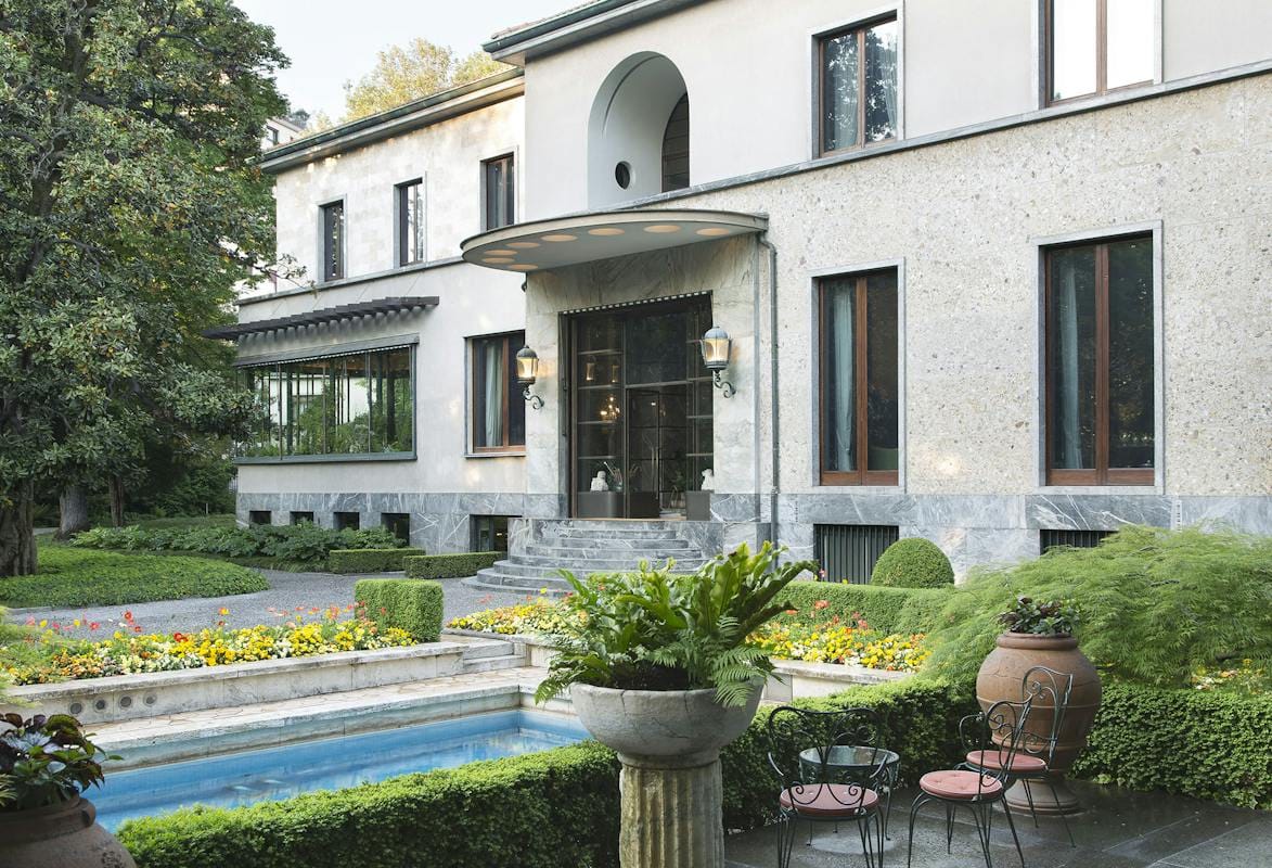 The entrance front, pool and garden