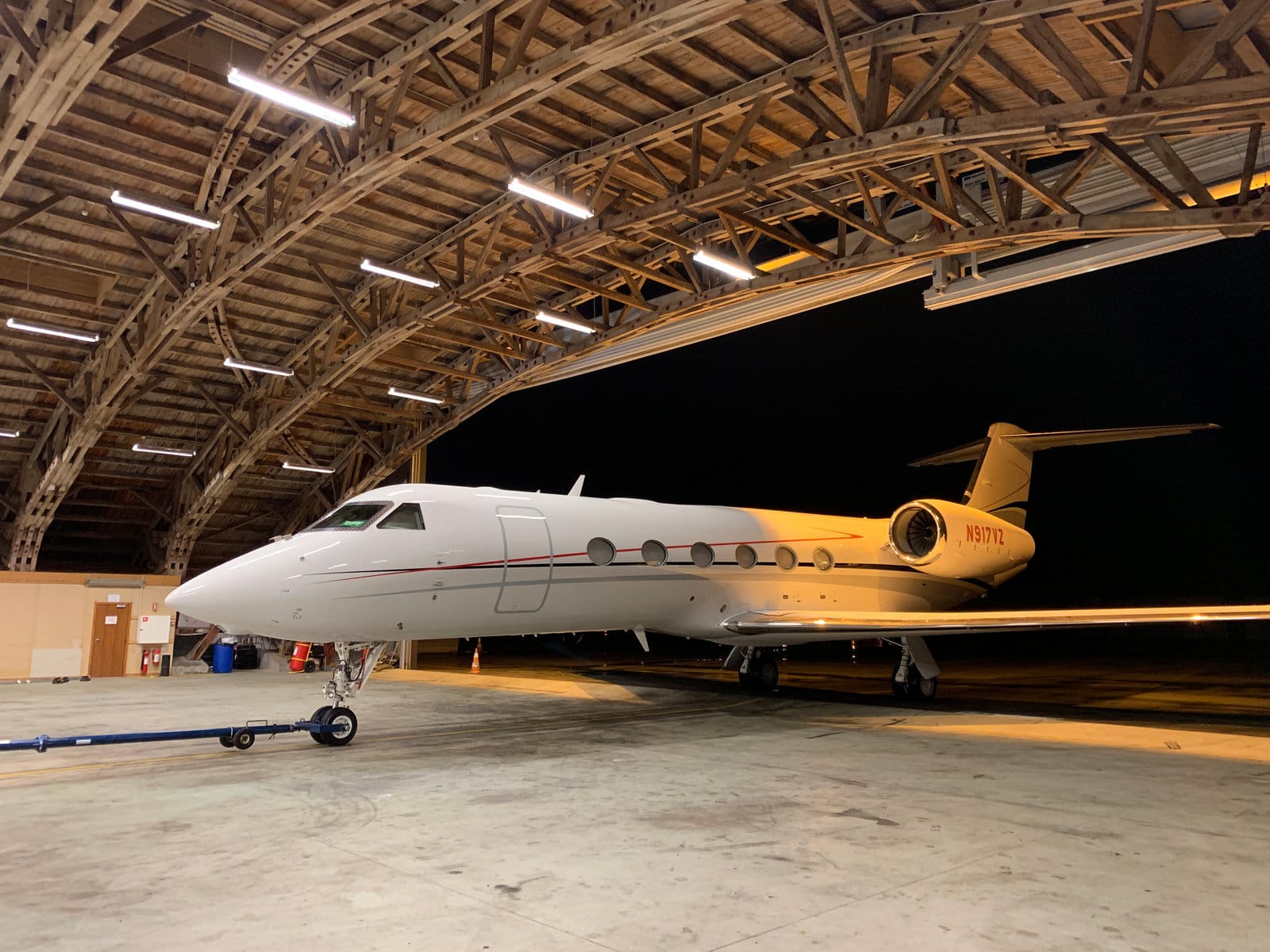 A private jet in an ASE hangar at night