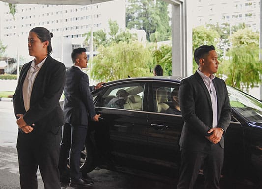 An executive protection team at a hotel car porch