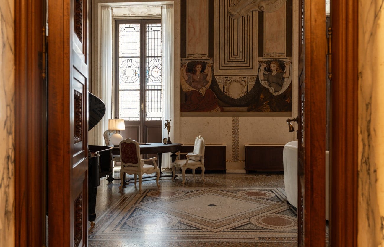 The piano and writing table on the mosaic floor